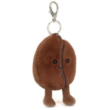 Plush keychain shaped like a coffee bean with a smiling face on a white background