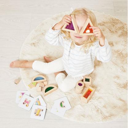 Child playing with wooden shape sorting toys on a soft surface