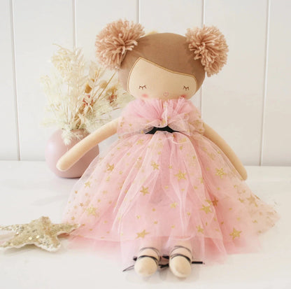 Toy doll with a pink dress and brown hair bun on a white background