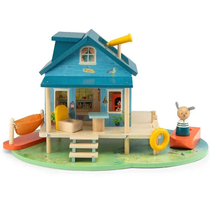 Toy house with a blue roof and wooden deck on a white background