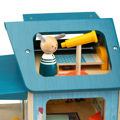 Wooden toy with a character holding a yellow telescope inside a blue playhouse.