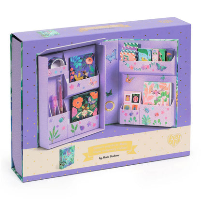 Purple stationery set with floral designs in an open box on a white background