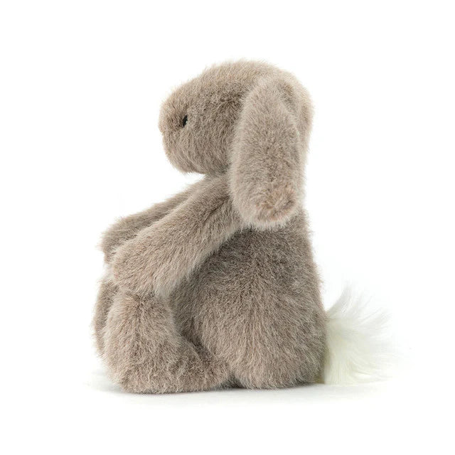 Fluffy beige plush toy bunny on a white background