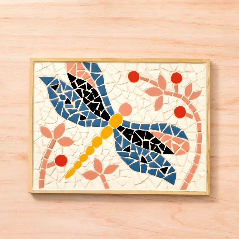 Mosaic artwork of a dragonfly on a wooden background