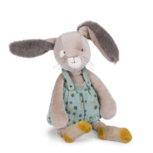 Stuffed bunny toy with a green polka dot outfit on a white background