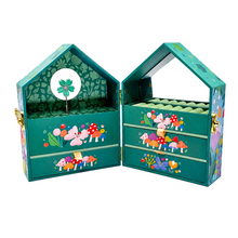 A decorative house-shaped jewelry box shown open, with two interior drawers, a top display shelf, and colorful mushroom and floral illustrations on a teal background. The box is photographed on a clean white studio background.