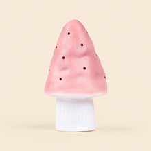 A mushroom-shaped night light with a pink perforated cap and a white cylindrical base, centered on a solid light beige background.