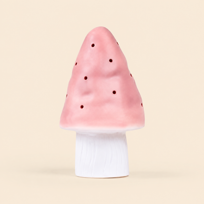 A mushroom-shaped night light with a pink perforated cap and a white cylindrical base, centered on a solid light beige background.
