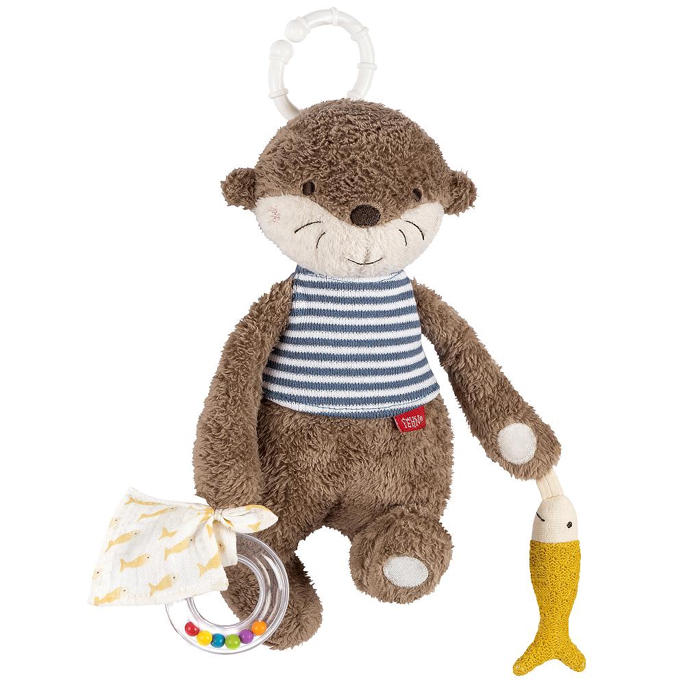 A plush toy representing an otter with a striped blue and white shirt, holding a yellow fish, and attached to a white C-ring for hanging.