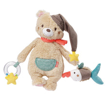 A plush toy resembling a bear with a nightcap, hanging straps, and additional playful elements such as a sawfish rattle and a rattle ring.