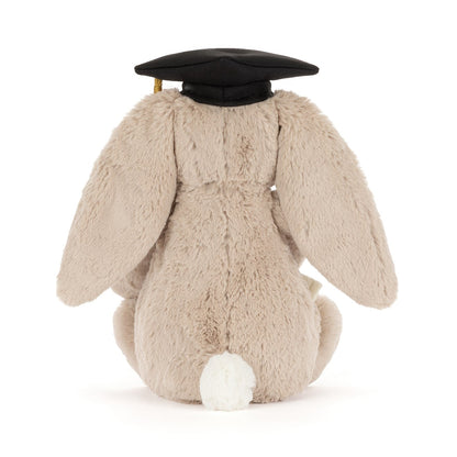 Fluffy beige bunny toy wearing a black graduation cap on a white background