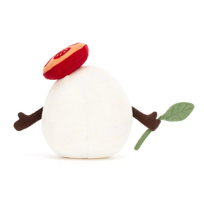 White plush toy shaped like a mozzarella with a red tomato hat, brown stem, and green leaf on a white background