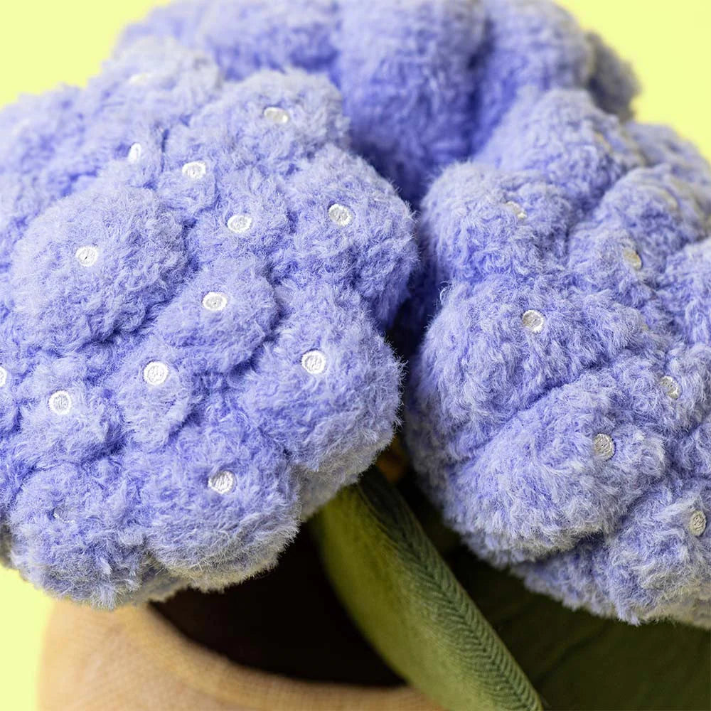 Purple fuzzy plush resembling hydrangea flowers with green leaves on a yellow background