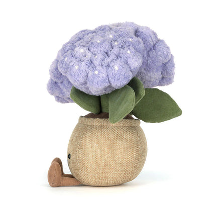 Stuffed toy resembling a purple flower in a beige pot on a white background