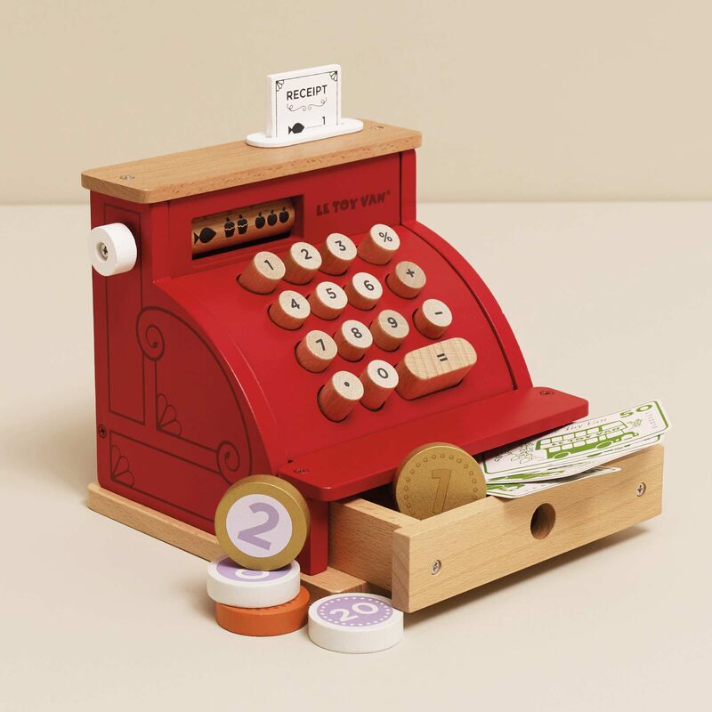 Toy cash register with wooden accents and a beige background