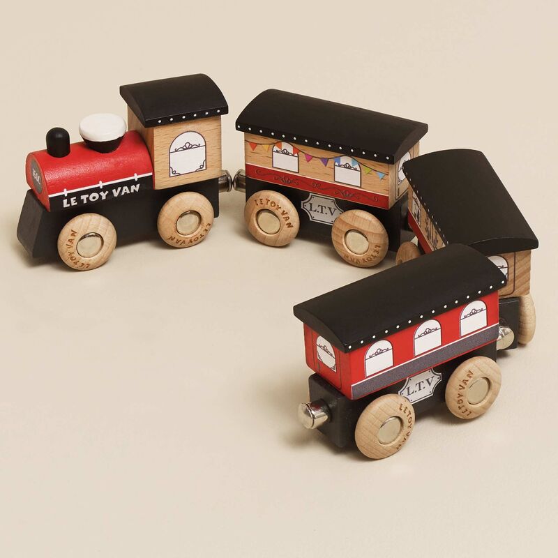 Wooden toy train set with red and black design on a beige background