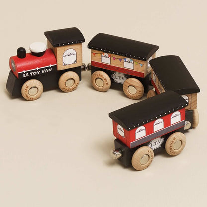 Wooden toy train set with red and black design on a beige background