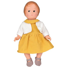 Doll wearing a yellow dress with a white shirt on a white background