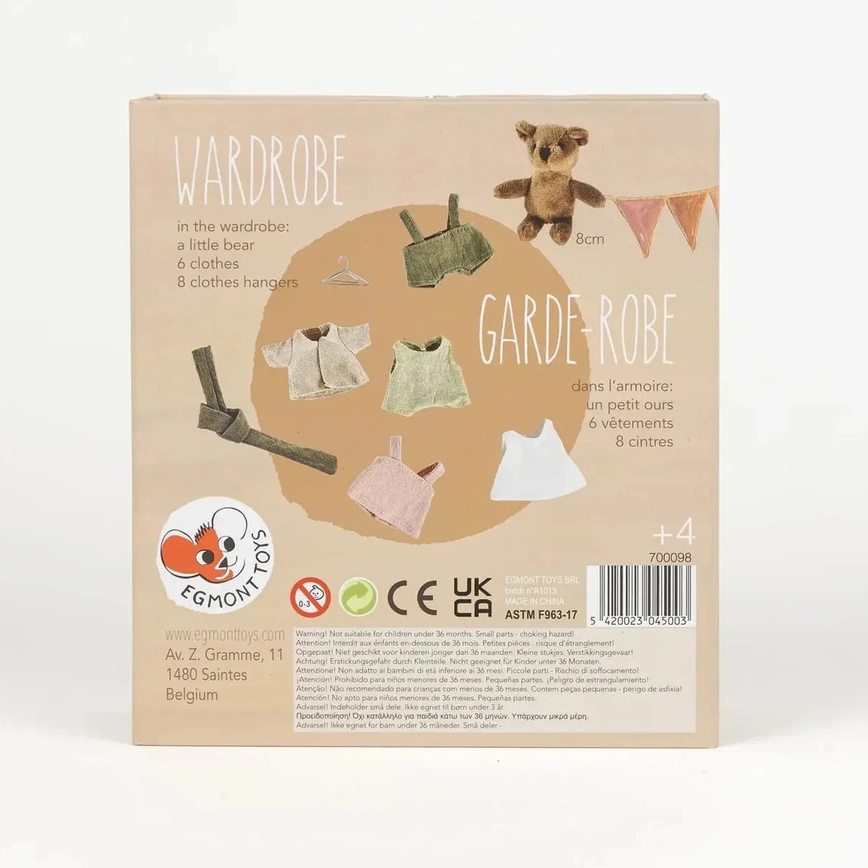 Package of a children's wardrobe set with clothes and a teddy bear on a beige background