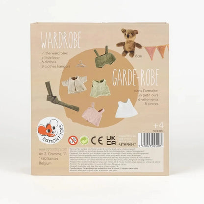 Package of a children's wardrobe set with clothes and a teddy bear on a beige background