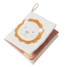 A soft plush safari book with a white background featuring a yellow and beige lion illustration and a small hanging loop.