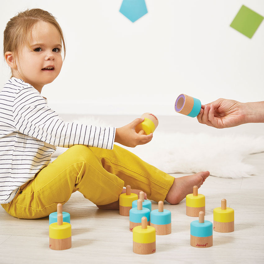 Child playing with colorful wooden toys on a light-colored floor.