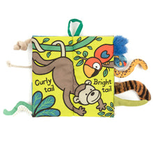 padded fabric book with jungle animal illustrations and 3D animal tails poking out.