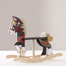 A traditional wooden rocking horse with hand and foot grips, decorated with a multicolored pattern and gold paint accents, on a white background.