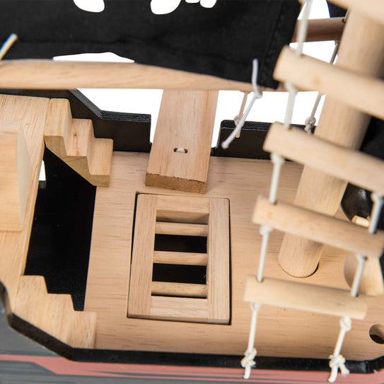 Close-up of a wooden pirate ship model with detailed structure.