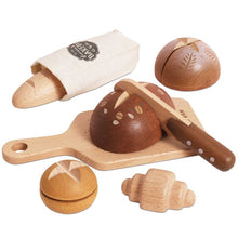 Wooden toy bakery set with various bread shapes and a rolling pin on a white background.