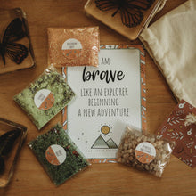 The image displays the Heart of an adventurer - Potion Pouch product, which includes four sparkly dry ingredients in biodegradable cellophane bags, a potion card, and a linen cloth bag, all laid out on a wooden surface with a magical theme.