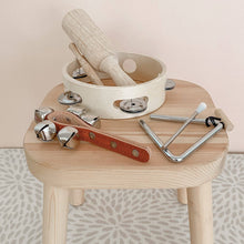 Love Note Co Little Sounds instruments arranged on a wooden stool in a softly styled playroom.