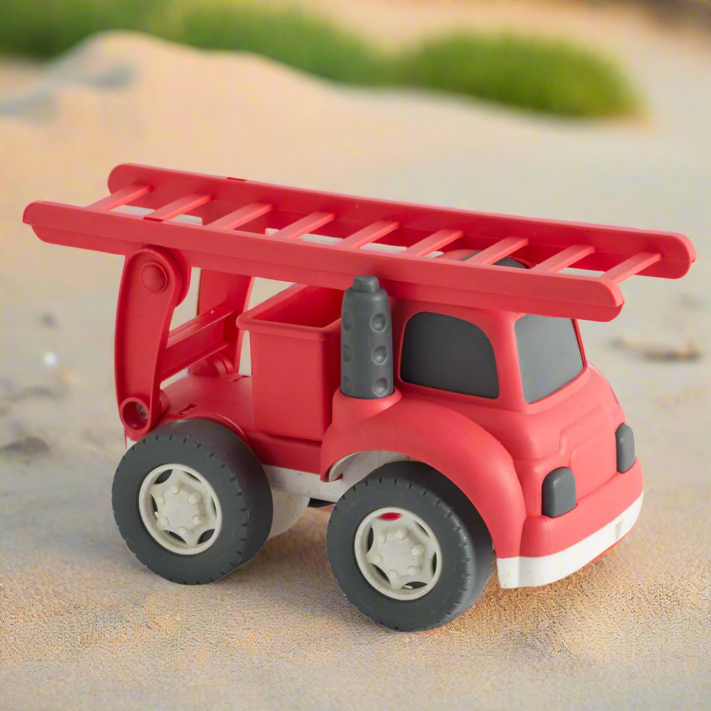 Red toy fire truck with a ladder on a white background