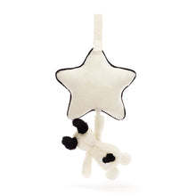 A black and cream colored plush puppy pull toy with a star-shaped hanger.