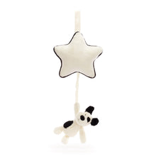 A black and cream colored plush puppy pull toy with a star-shaped hanger.