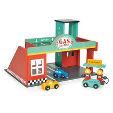 A colorful gas station garage toy set featuring a service station with a red building, green pumps, and a road ramp. Two toy cars are also included.