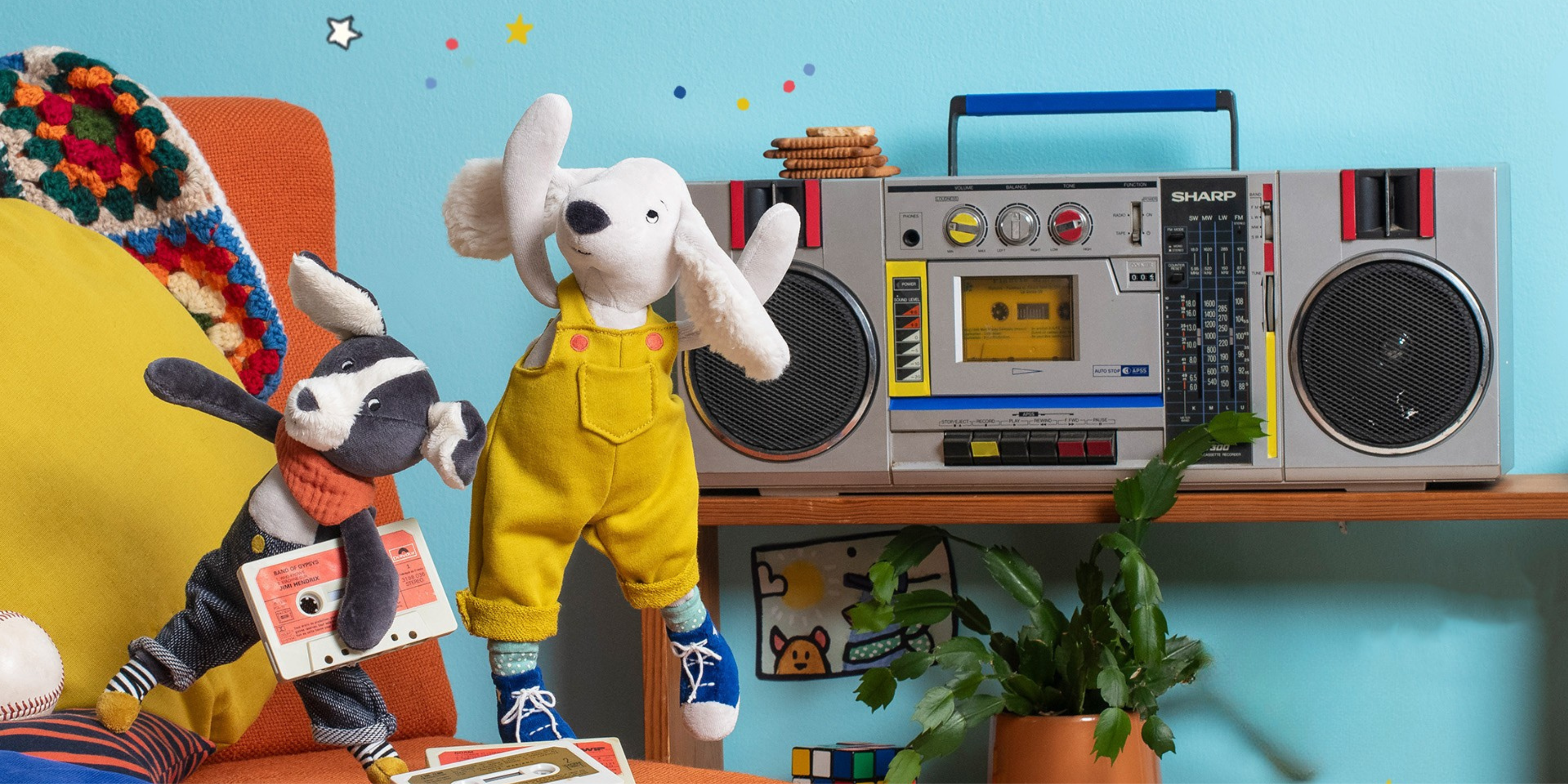 Toy dogs with a boombox on a shelf against a blue wall