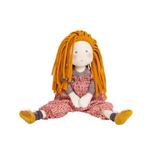 Toy doll with long orange hair and a red dress on a white background