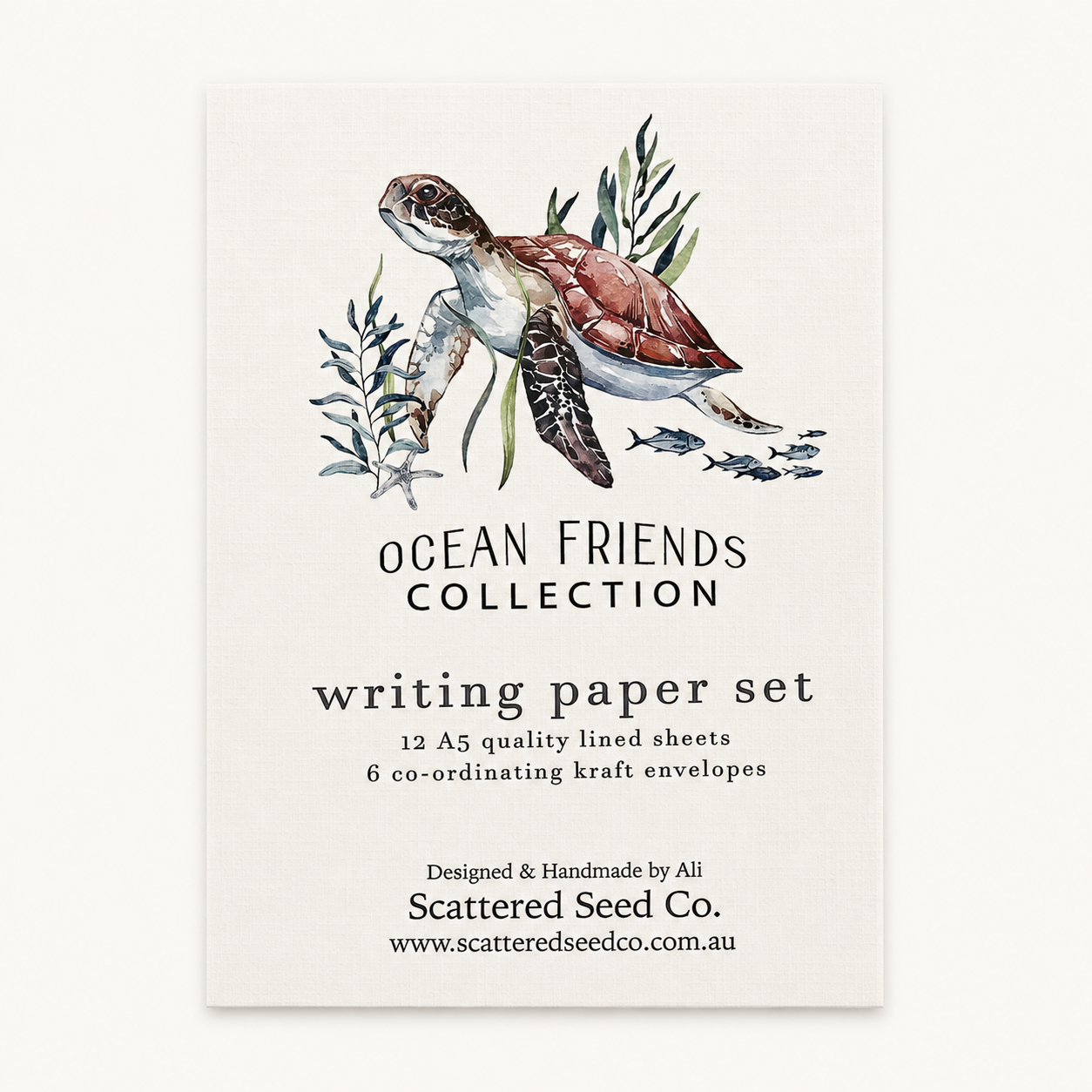 A vertical paper card or packaging insert for a writing paper set, featuring an illustrated sea turtle with seaweed and small fish above the text 'OCEAN FRIENDS COLLECTION' and 'writing paper set.' The card is photographed against a plain light background.