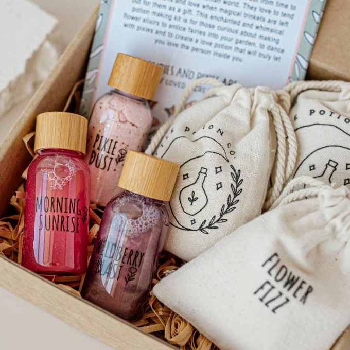 Set of small bottles with labels and drawstring bags in a box