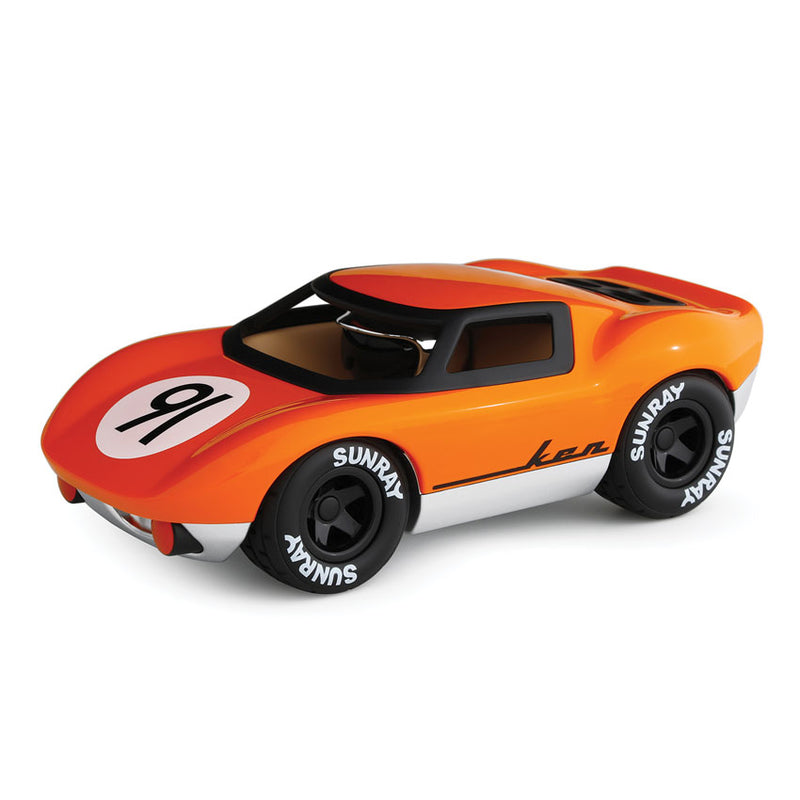 A miniature orange and black racing vehicle toy with a number '9' on the side and the brand name 'Ken' on the front. It has black wheels with tires, a chrome helmet, and is presented against a white background.