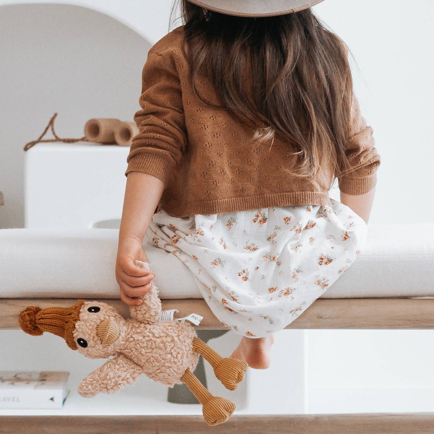 Child holding a duck soft toy in a home setting