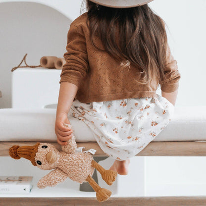 Child holding a duck soft toy in a home setting