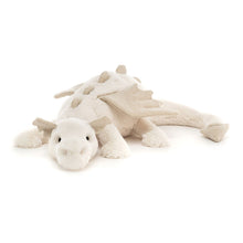 A plush toy resembling a white dragon with a creamy texture, featuring sparkly spines, ears, wings, and a tail.