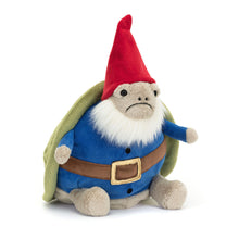 A plush toy depicting a garden gnome with a turtle shell, wearing a blue tunic, brown belt, green cape, and a red hat.