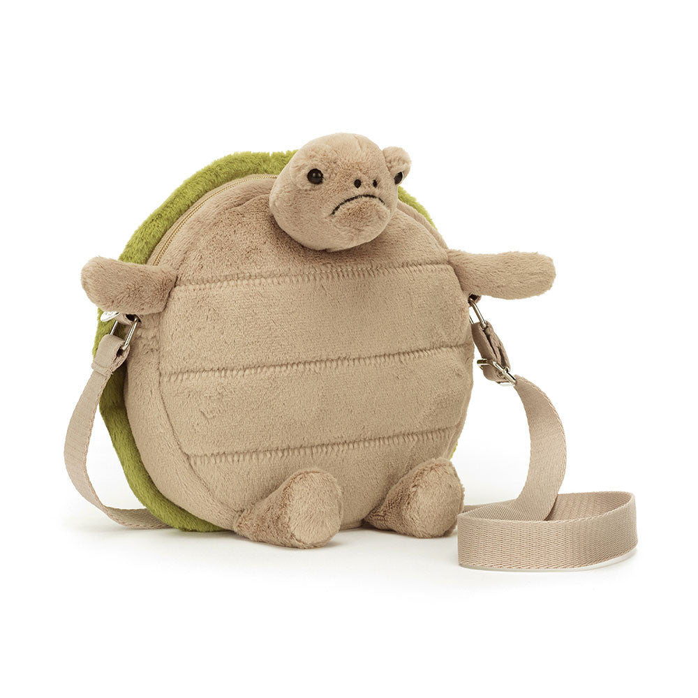 A beige fabric turtle-shaped bag with a green embroidered shell, featuring a silver zipper and a webbed strap.
