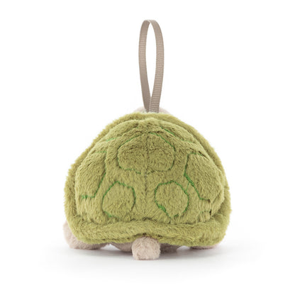 Green plush soft toy resemblinnbg a turtle with a hanging strap on a white background