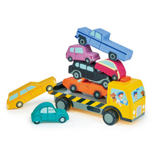 A set of colorful wooden toy cars stacked on top of each other on a wheeled recovery truck.