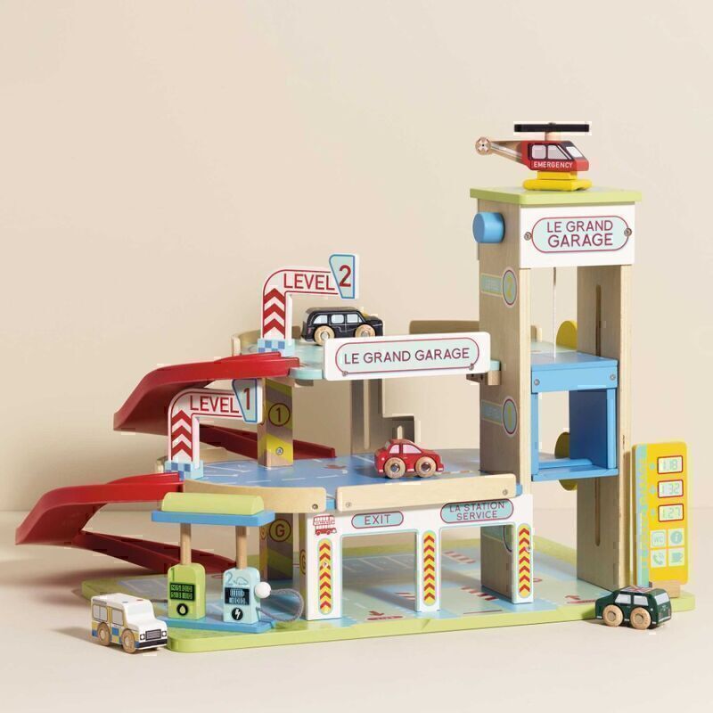 Toy garage set with multiple levels and cars on a beige background