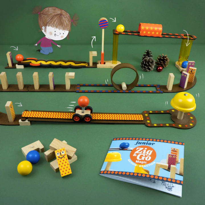 Toy track set with cars and book on a green background